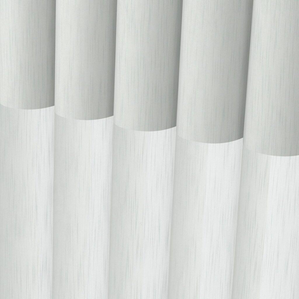 Close-up of white sheer window panels with soft texture and subtle vertical lines, showcasing elegant window treatment for light filtering.